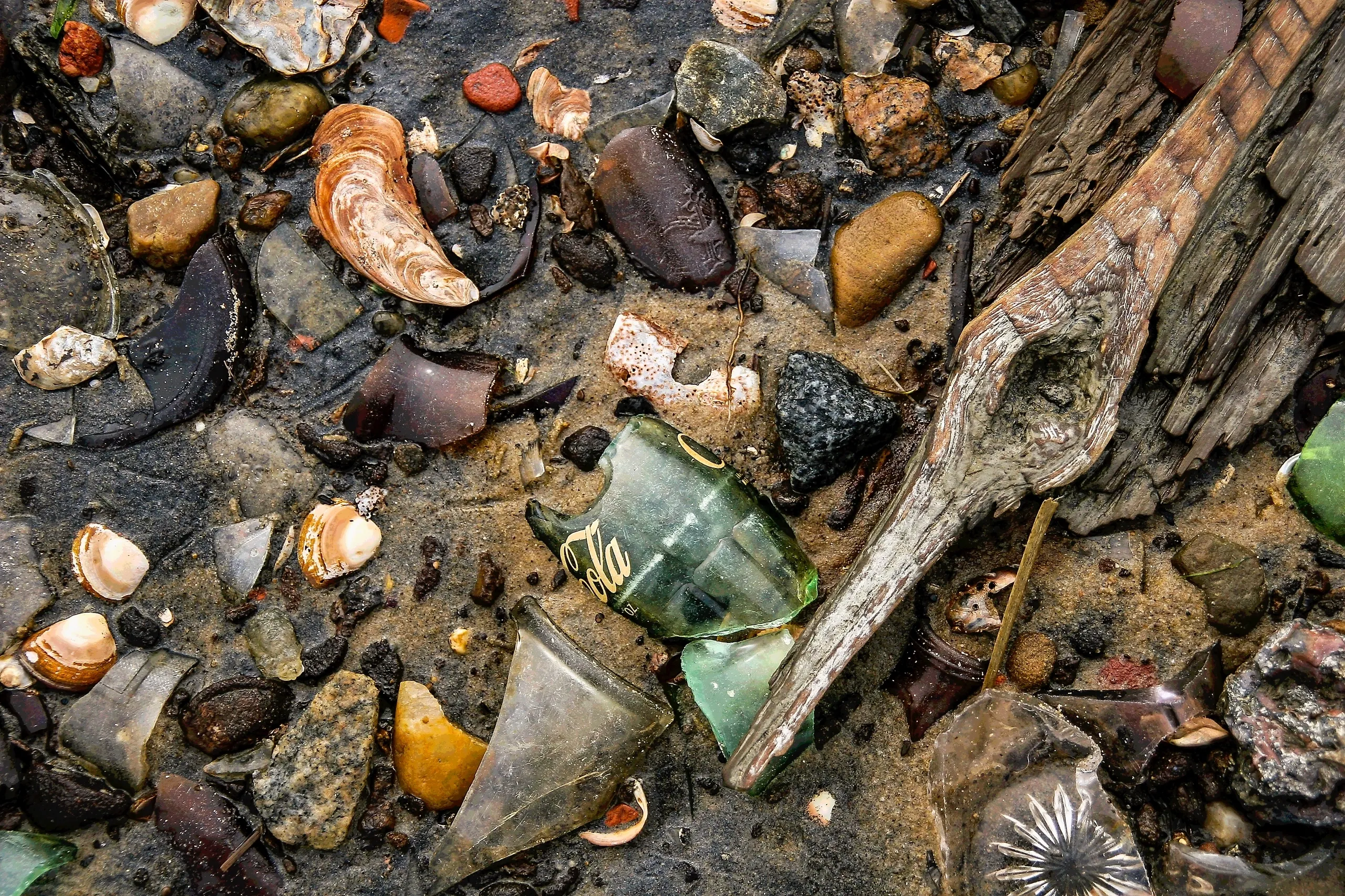 Colorful stones and sea glass on sand.