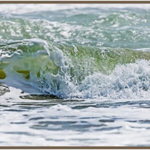 A close-up of a small wave crashing onto the shore.